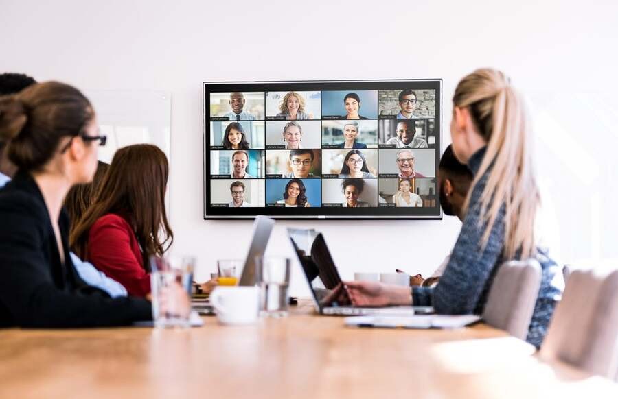 An in-house team engages in a meeting with a remote team through Crestron meeting room technology.